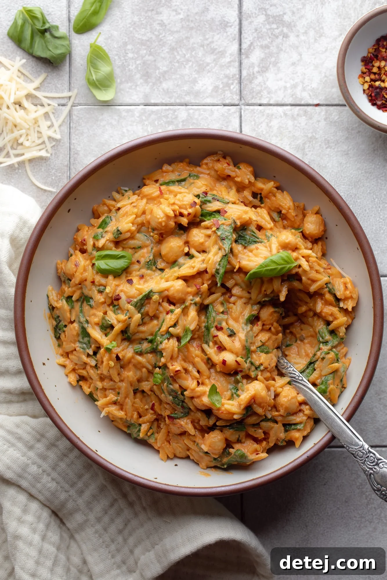 A vibrant bowl of One Pot Creamy Tomato Orzo, garnished with fresh basil, ready to be served.