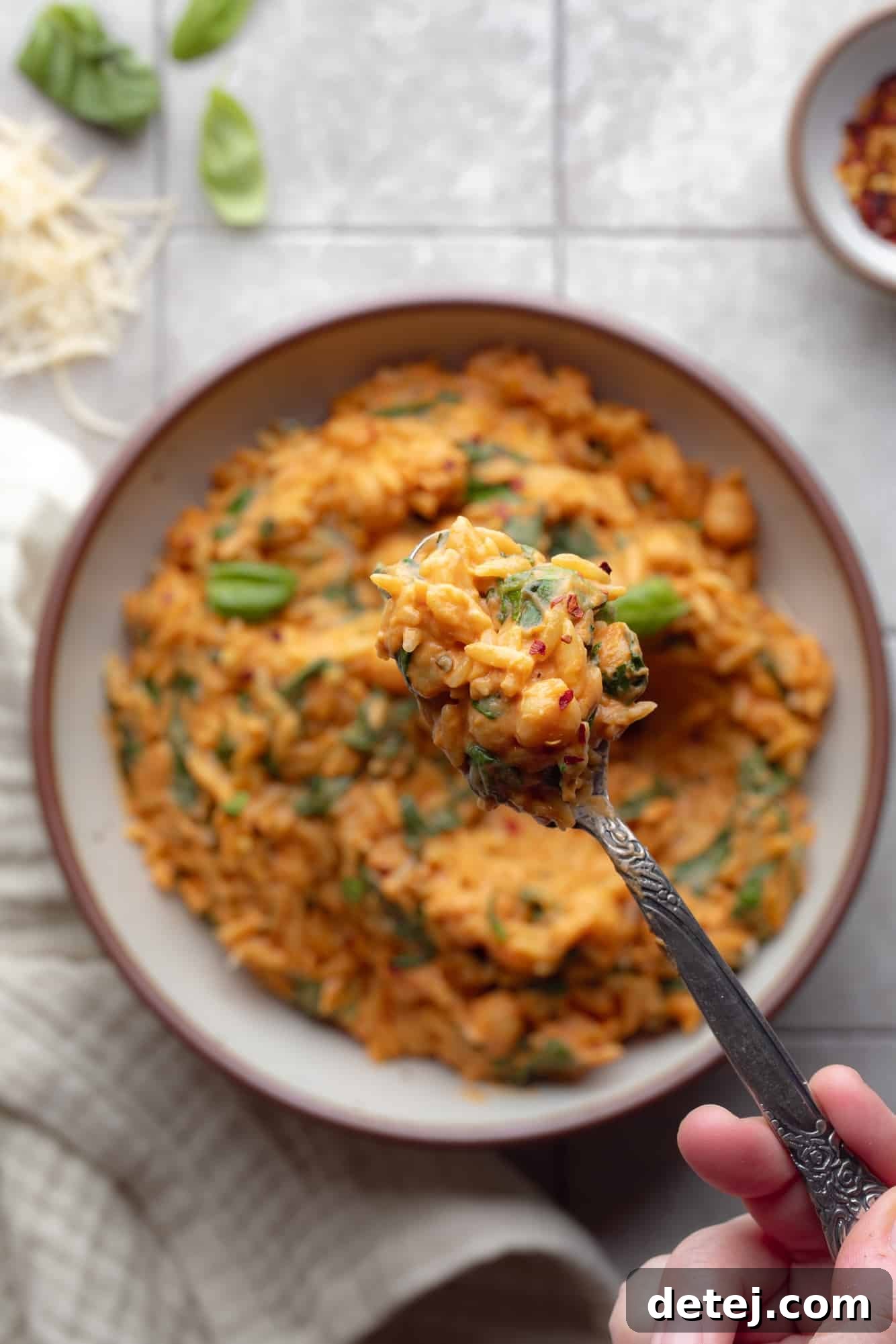 A close-up shot of a spoonful of One Pot Creamy Tomato Orzo, highlighting the rich sauce and tender pasta.