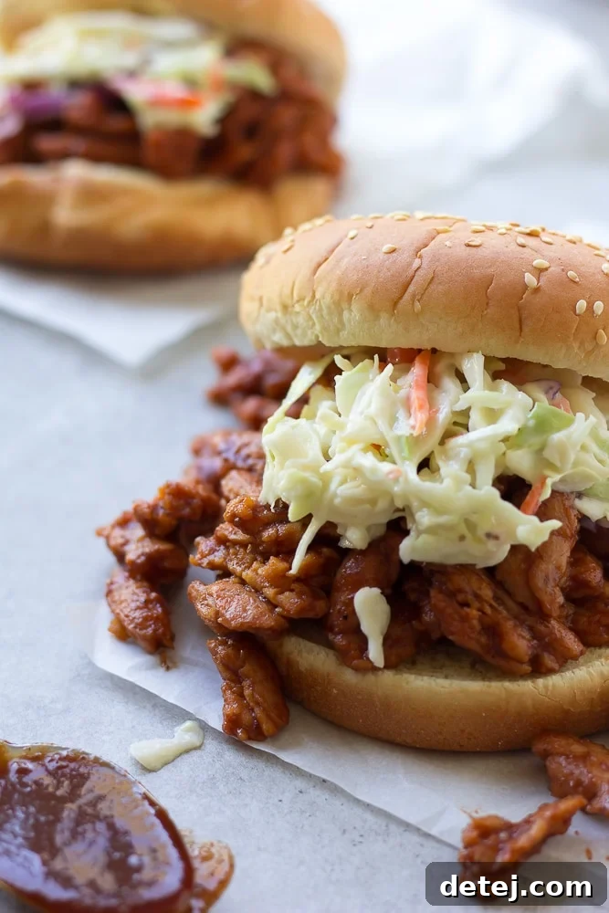 Ultimate Vegan BBQ Soy Curl Sandwich 2 vegan bbq sandwich on parchment paper with coleslaw