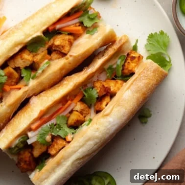 overhead view of two vegan banh mi sandwiches on a white plate.