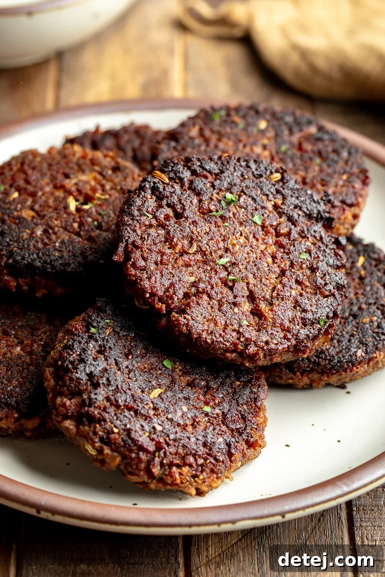 close up on a pile of vegan breakfast sausage patties on a plate.