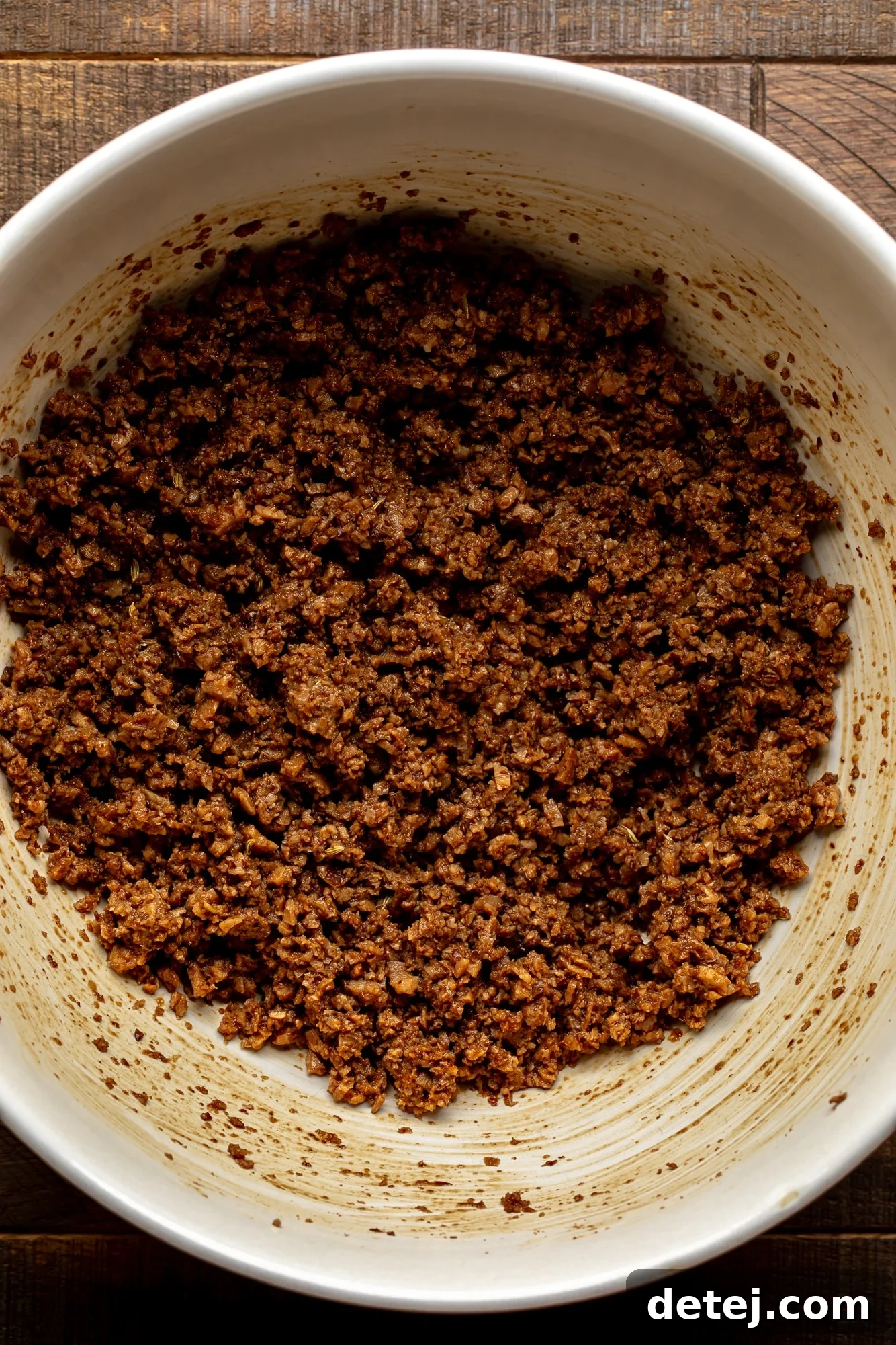 the meaty soy crumble mixture for vegan breakfast sausages in a large white bowl.