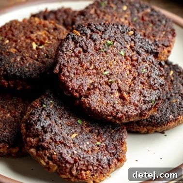 close up on a pile of vegan breakfast sausage patties on a plate.