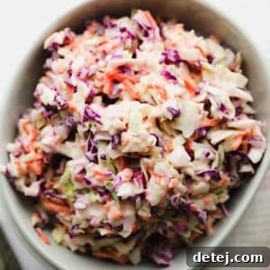 Square image of a bowl of creamy vegan coleslaw.