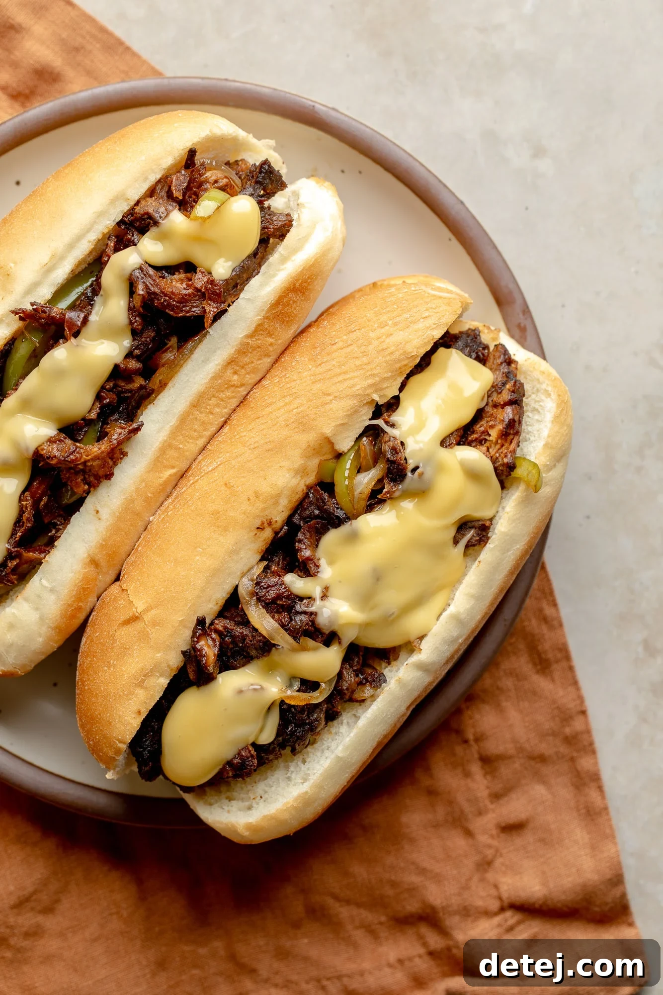 Plant-Based Philly Delight 7 Two perfectly assembled vegan philly cheesesteak sandwiches on a white plate, ready to be enjoyed.