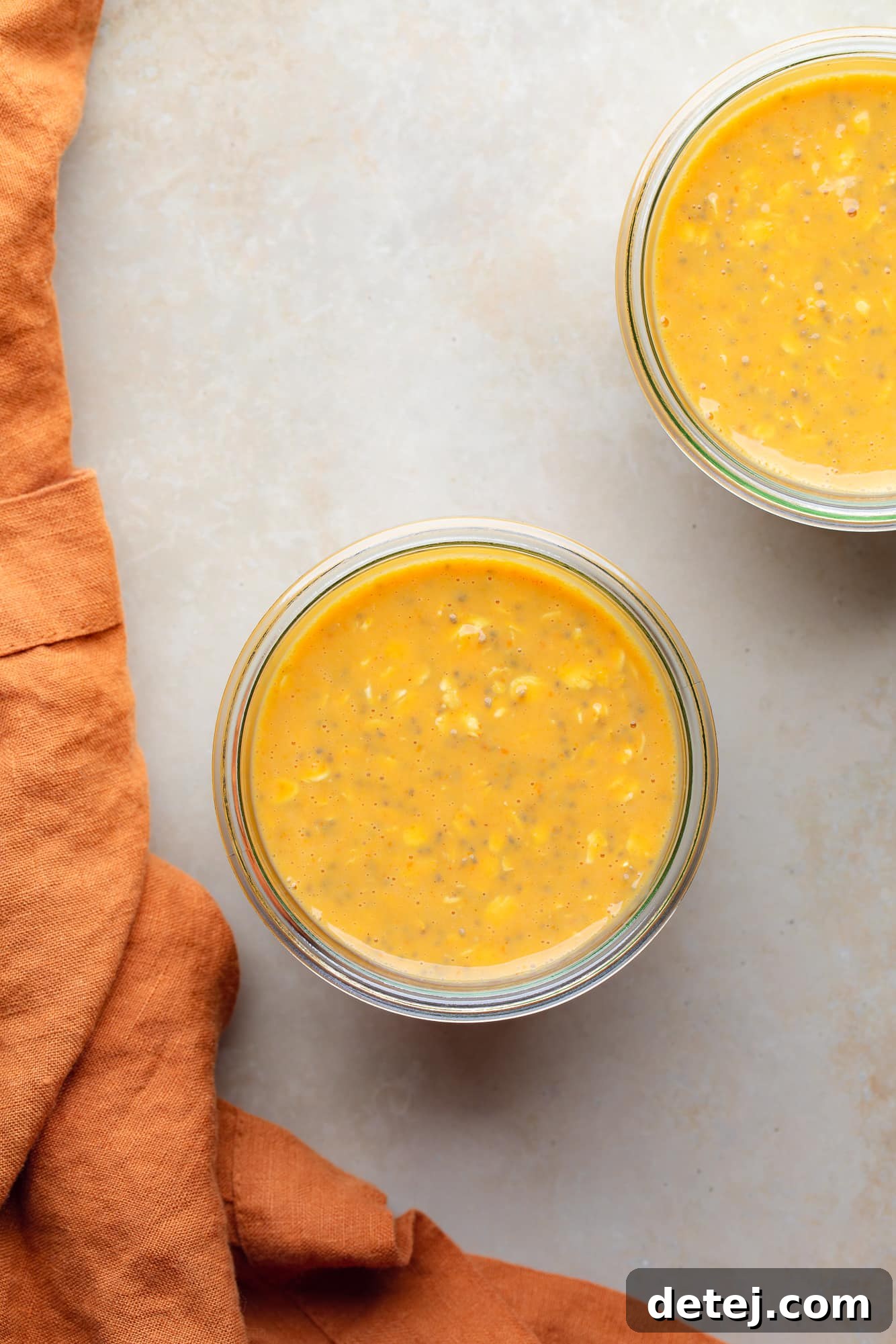 overhead view of 2 a glass jars of pumpkin overnight oats.