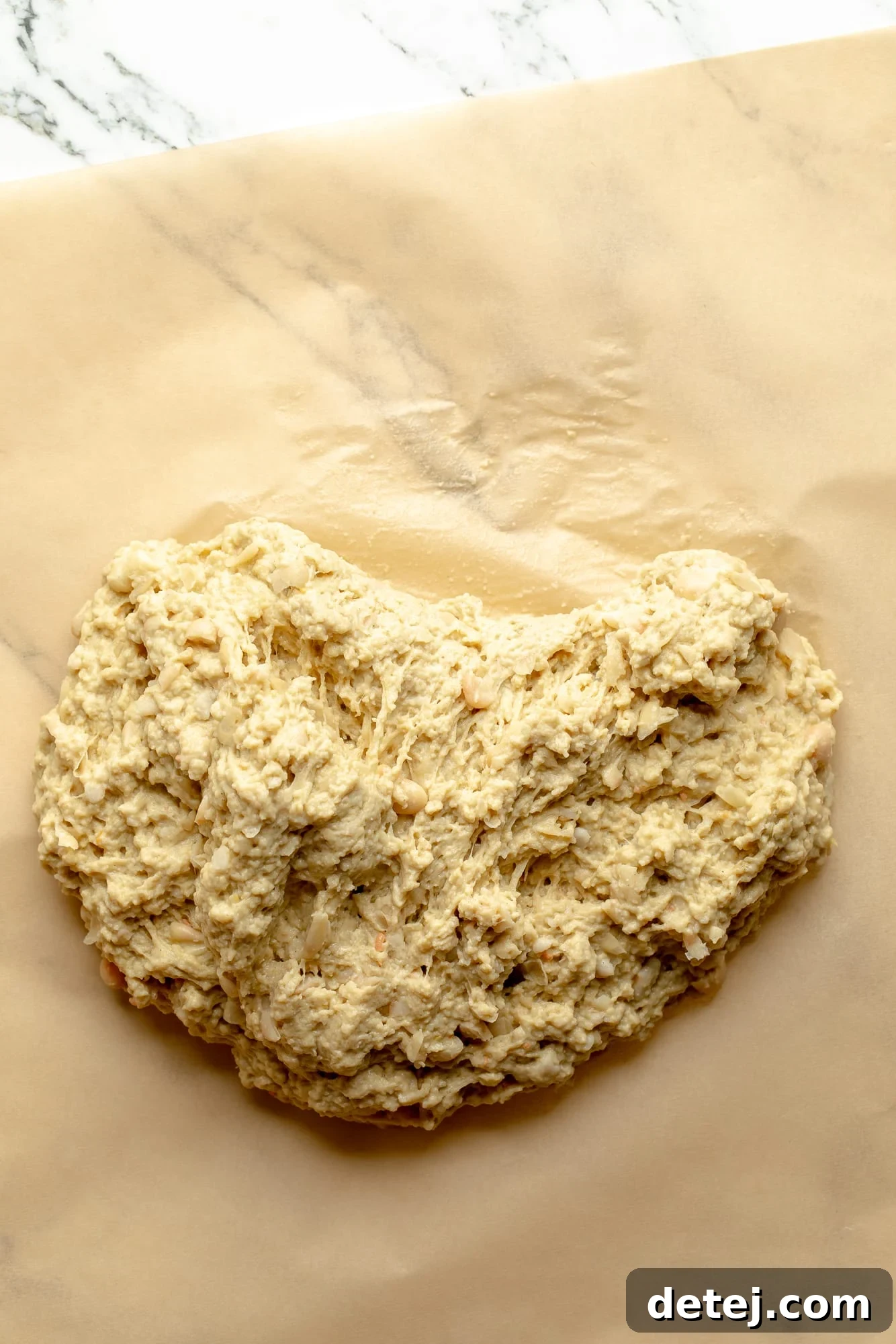 Overhead view of seitan dough on parchment paper, showing the prepared dough.