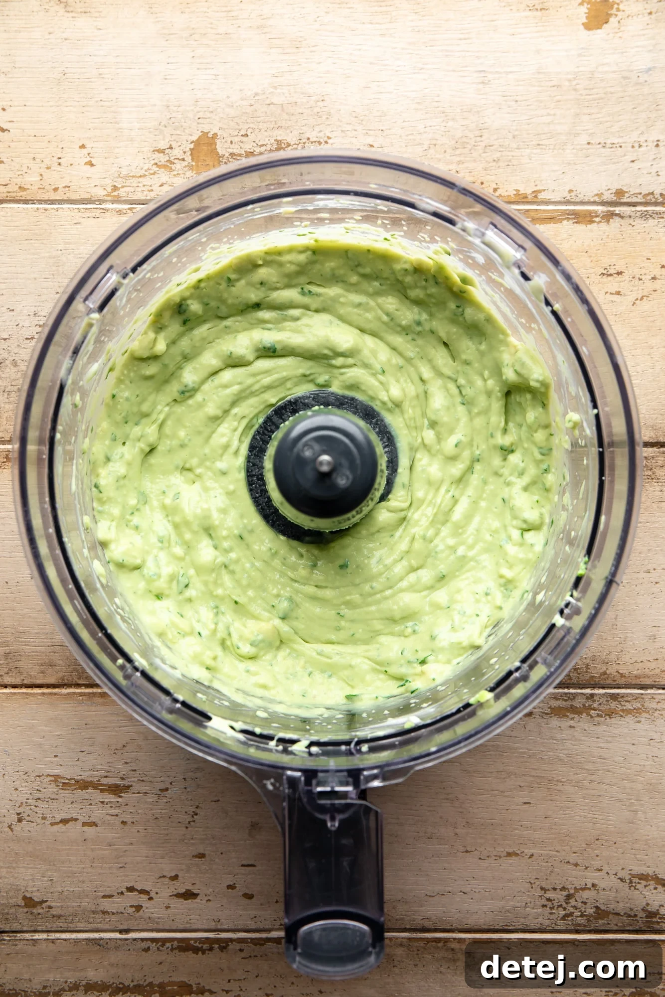 blended vegan avocado crema with a smooth, creamy texture in a food processor, ready to be served.