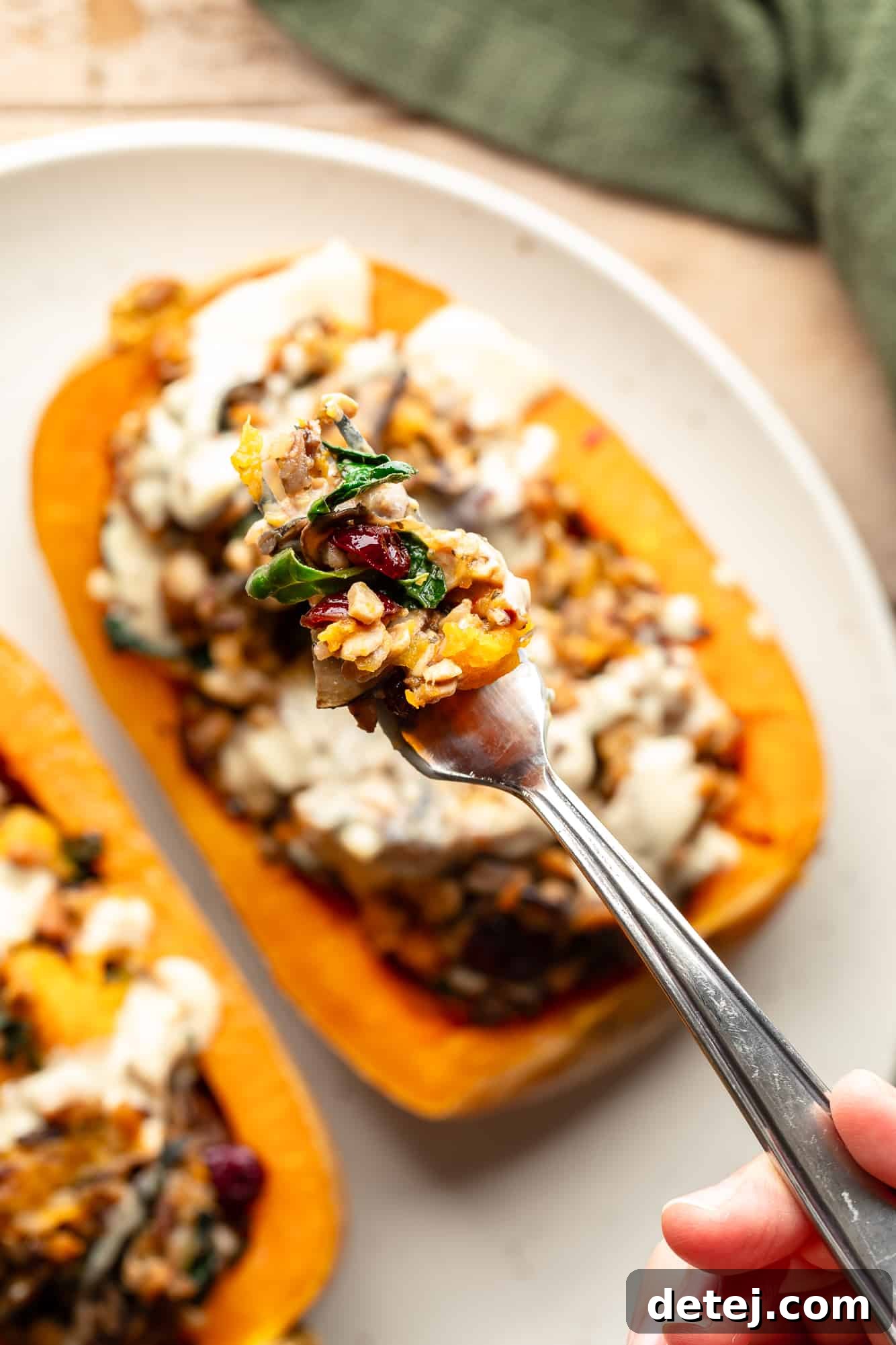 close up on a forkful of savory stuffing taken from a stuffed butternut squash, showing the rich textures.