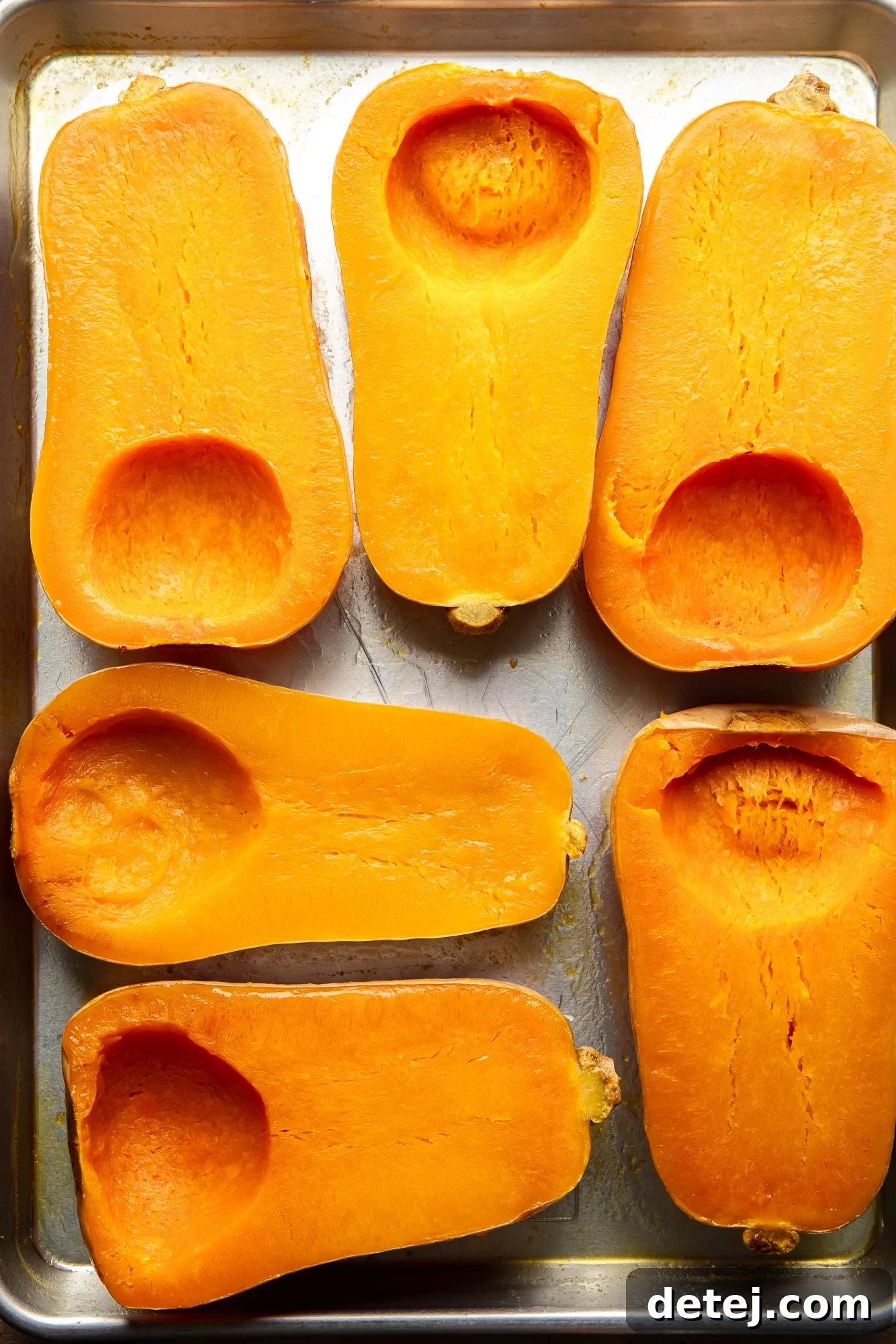 roasted butternut squashes on a baking sheet, showing their beautifully caramelized edges.