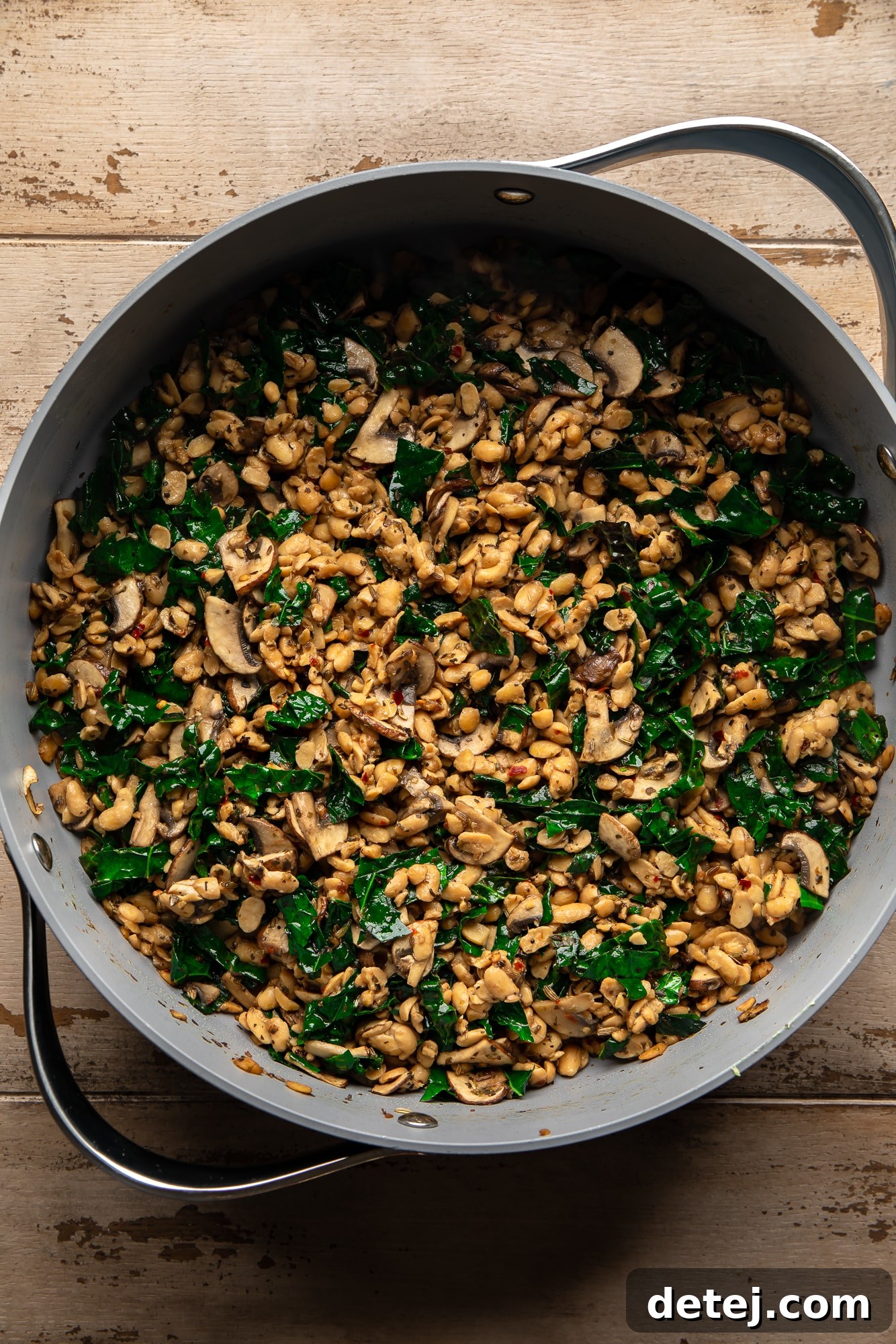 overhead view of a vibrant tempeh and wild rice stuffing for stuffed butternut squash in a large pot, ready to be scooped.