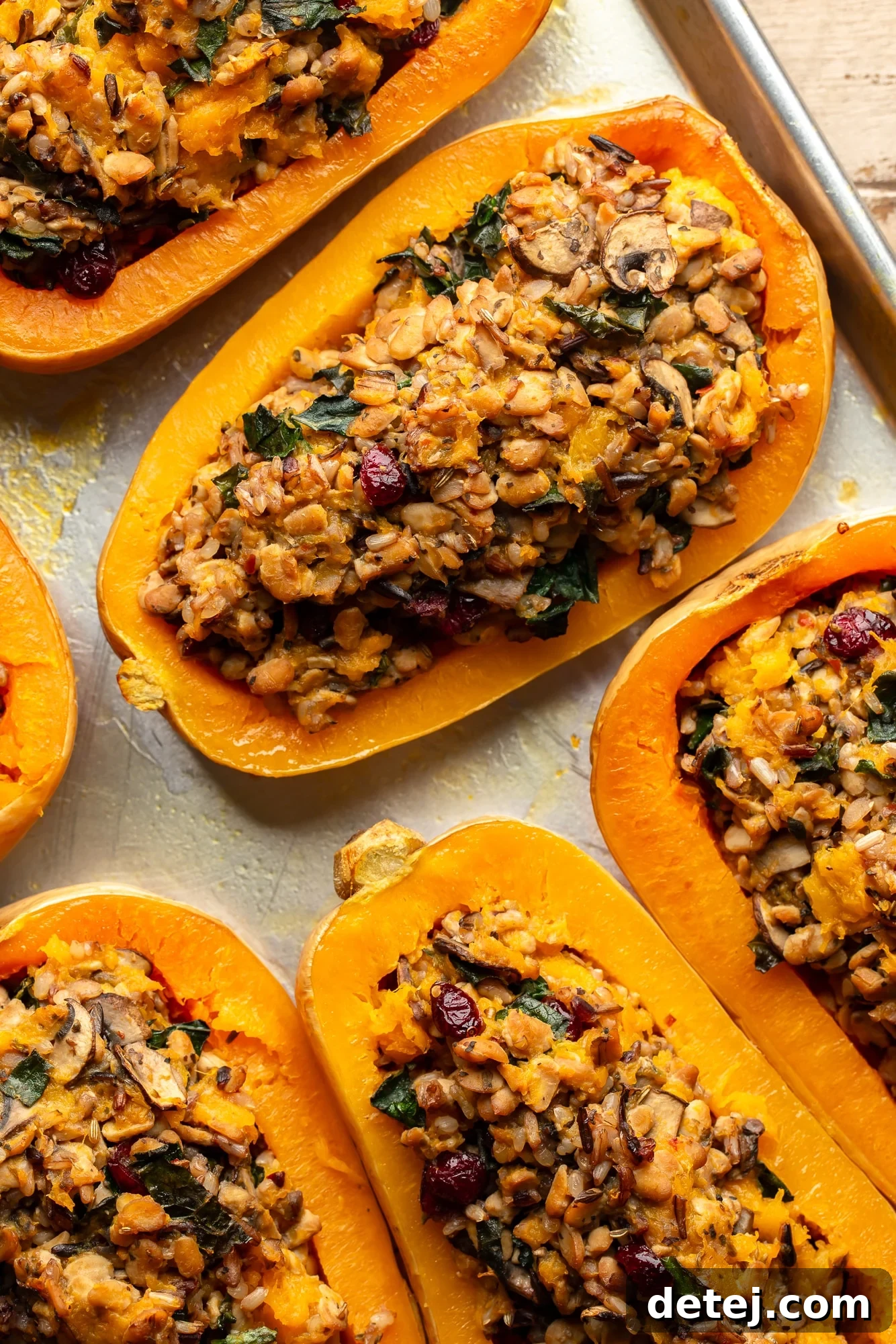 overhead view of perfectly baked stuffed butternut squashes on a baking sheet, golden and inviting.