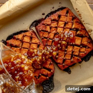 overhead view of a pineapple glaze being poured over a tofu ham roast in a parchment-lined baking dish.