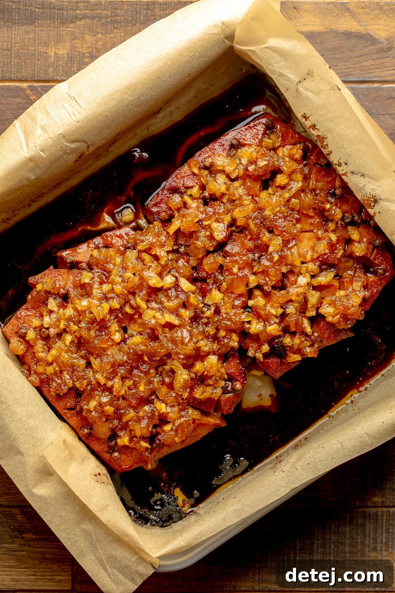 overhead view of a pineapple glazed tofu roast in a parchment-lined baking dish.