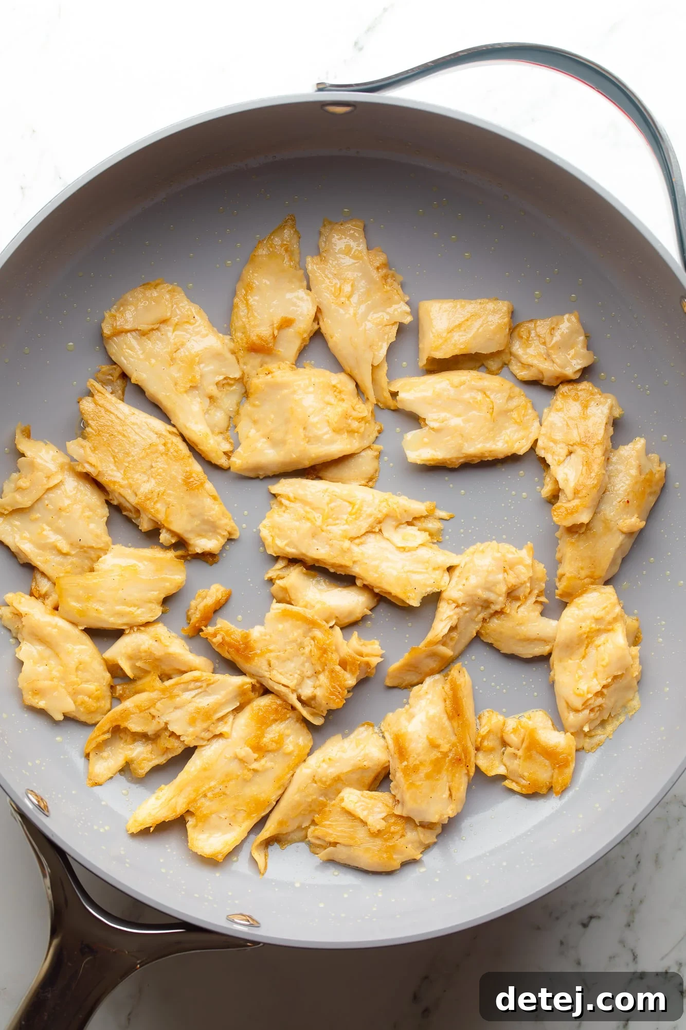overhead view of cooked vegan chicken pieces for vegan marry me pasta in a large skillet.