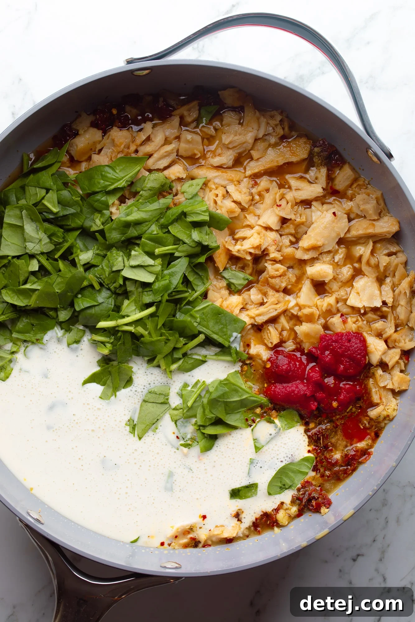 overhead view of the ingredients for vegan marry me pasta sauce in a large skillet.