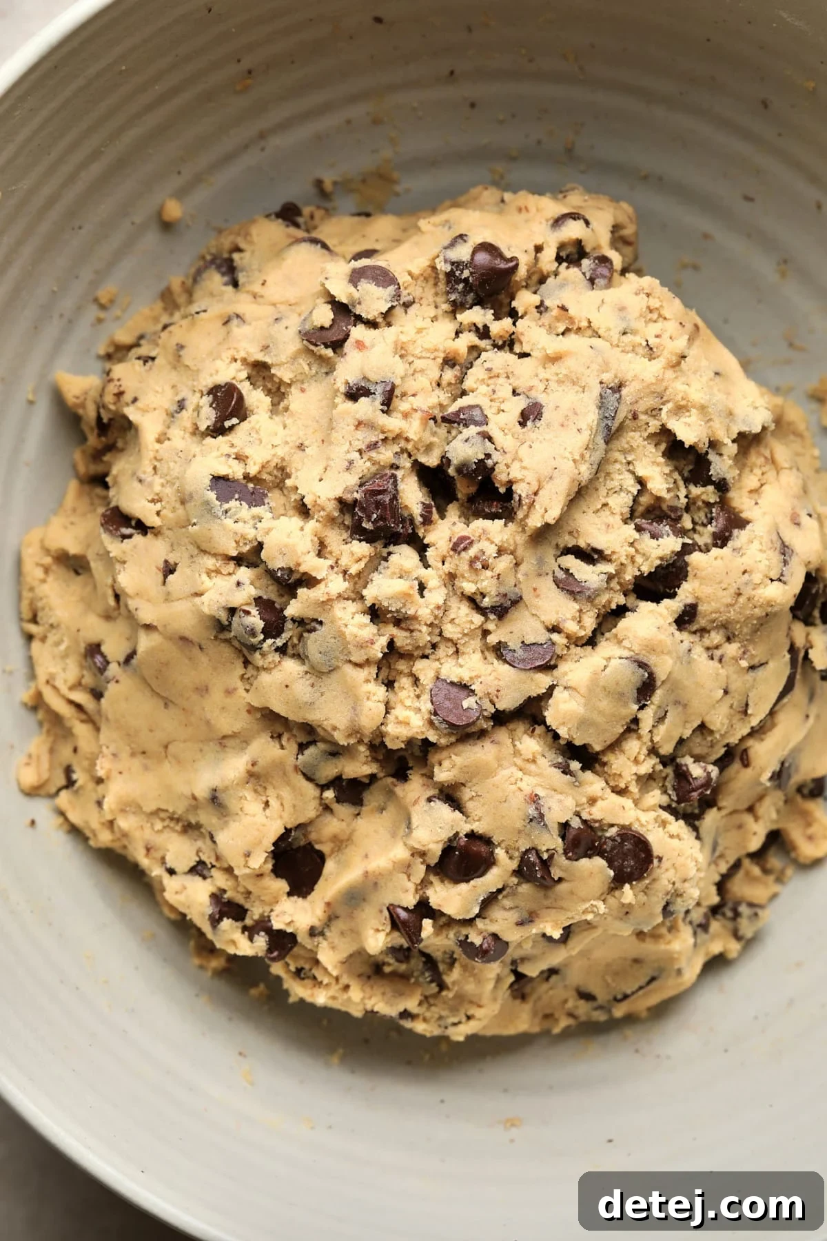 A bowl filled with perfectly mixed vegan chocolate chip cookie dough, showcasing its rich texture and abundant chocolate pieces, ready for baking.