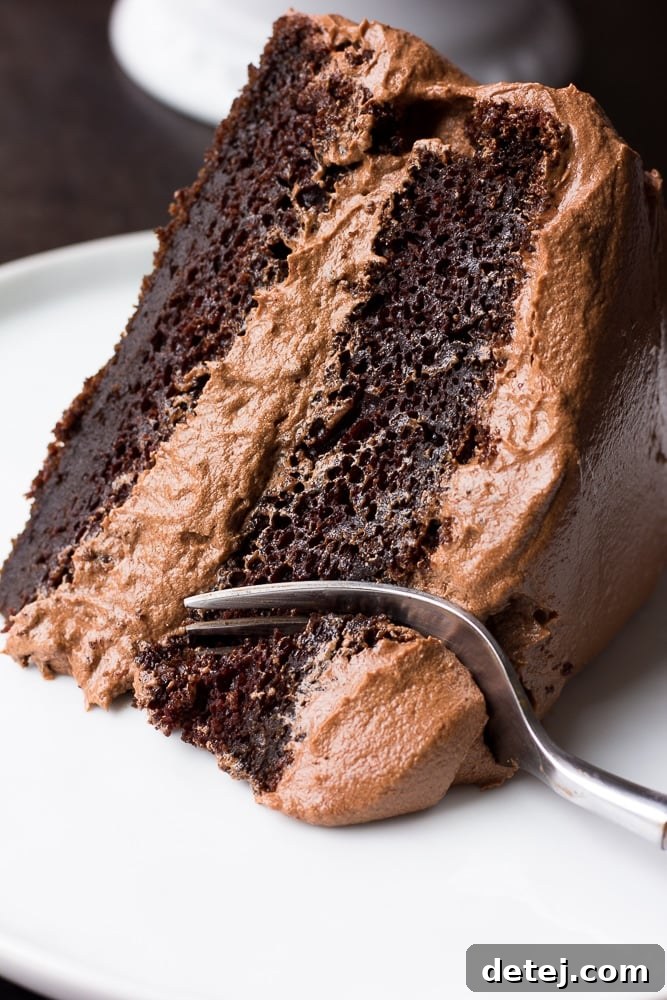 slice of vegan chocolate cake with a fork taking a bite.