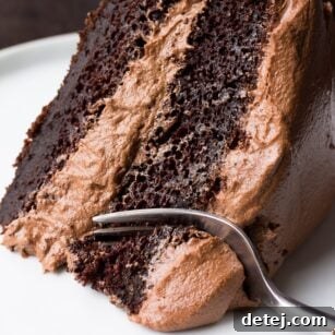 slice of vegan chocolate cake with a fork taking a bite.