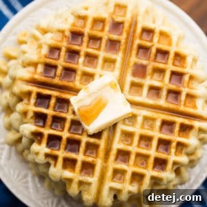 Square image of vegan gluten-free waffles on a plate with butter