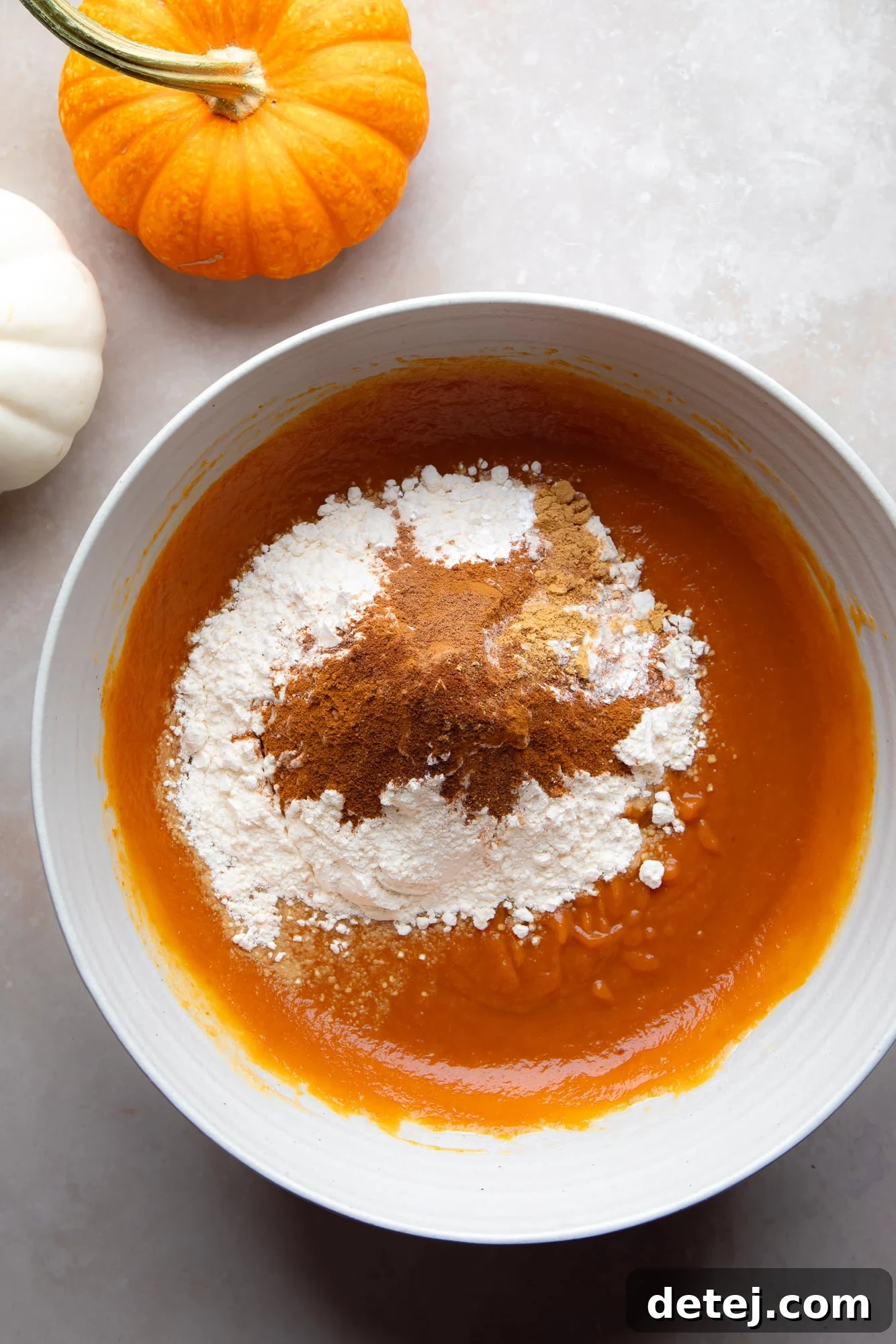The perfectly combined dry and wet ingredients for Vegan Pumpkin Muffins in a large bowl, ready for mixing.
