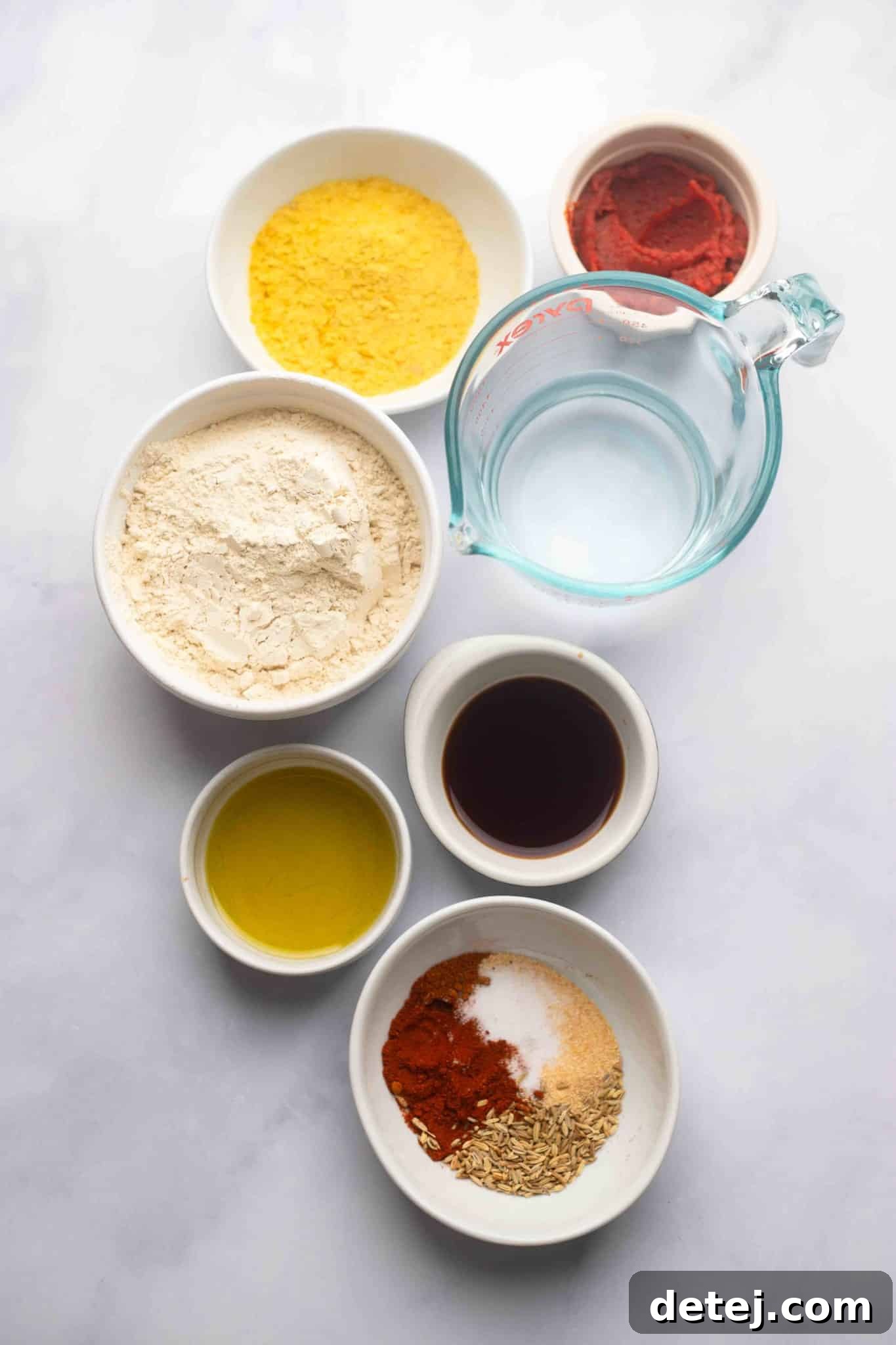 Plant-Powered Pepperoni 4 Individual white bowls showcasing the precise measurements of ingredients for vegan pepperoni, including vital wheat gluten, various spices, tomato paste, and liquids.