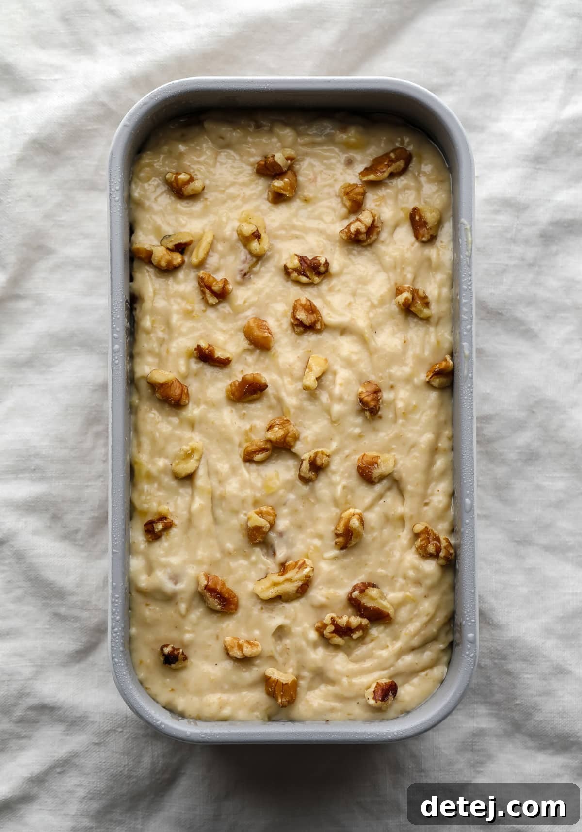 unbaked loaf of vegan banana bread with walnuts sprinkled on top