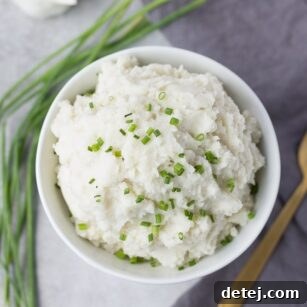 A bowl of vegan mashed potatoes, garnished and ready to serve.