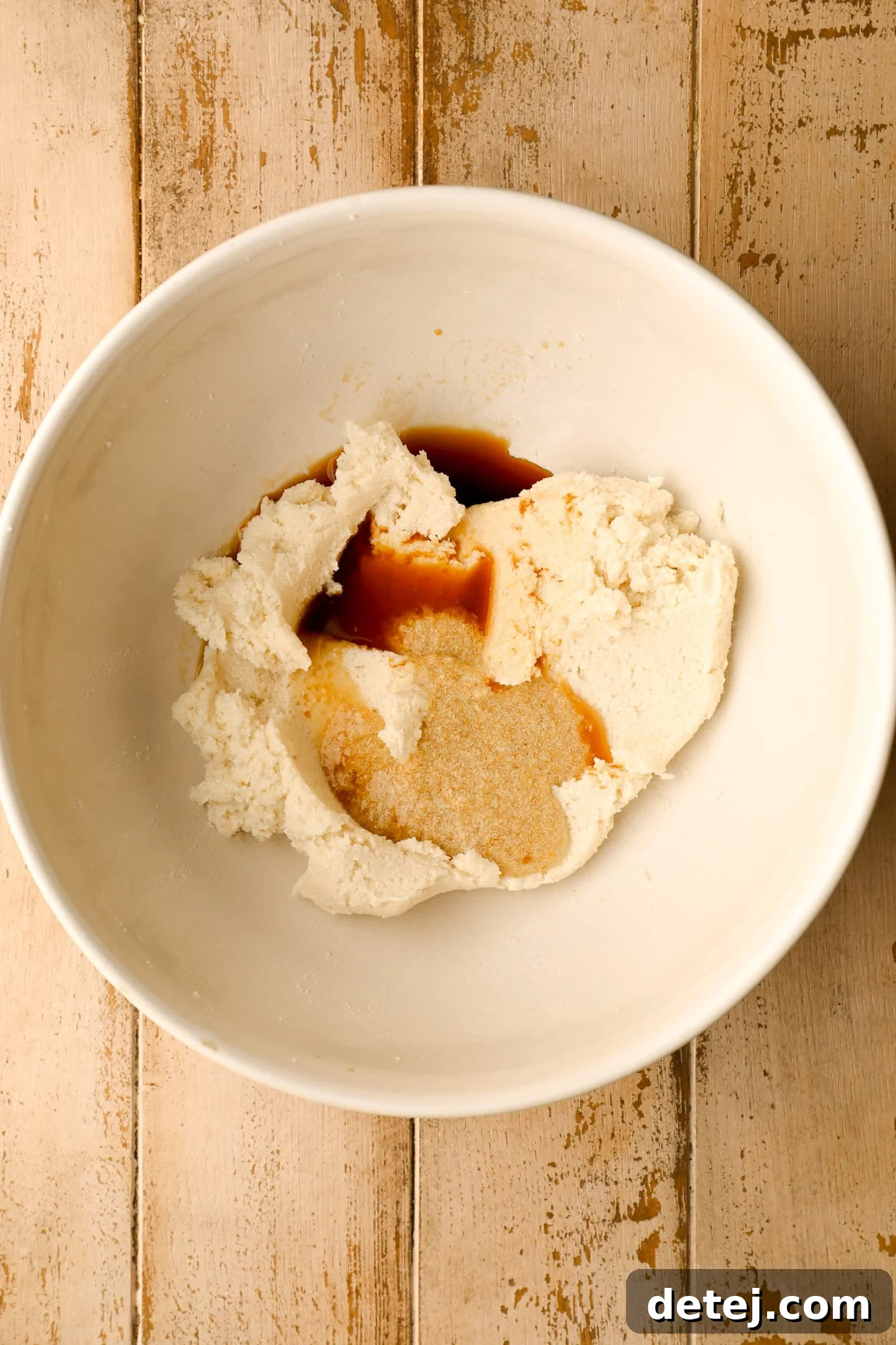 Wet ingredients for vegan snickerdoodles beautifully mixed in a white bowl, ready for dry ingredients.
