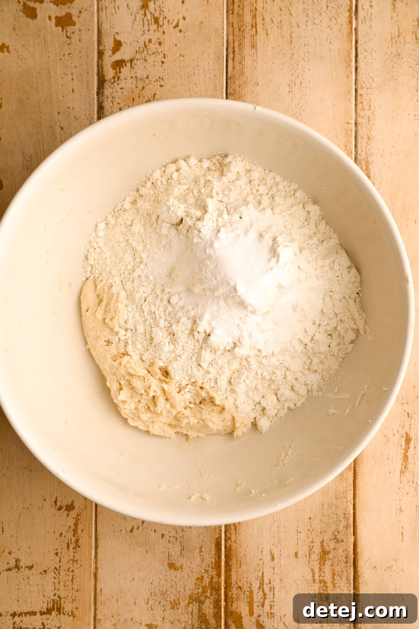 Dry ingredients for vegan snickerdoodles perfectly measured and combined in a separate white bowl.