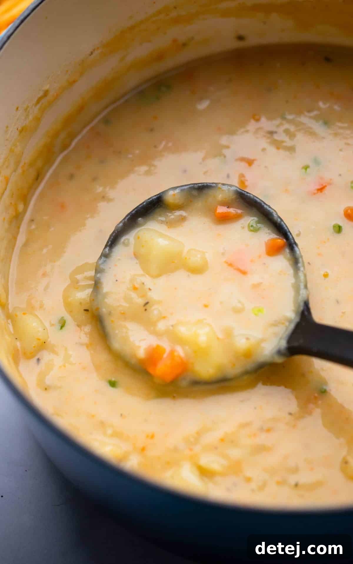 ladle with creamy potato soup in a pot