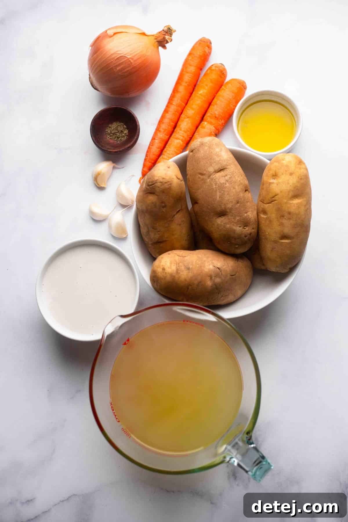 ingredients for potato soup on white marble backdrop