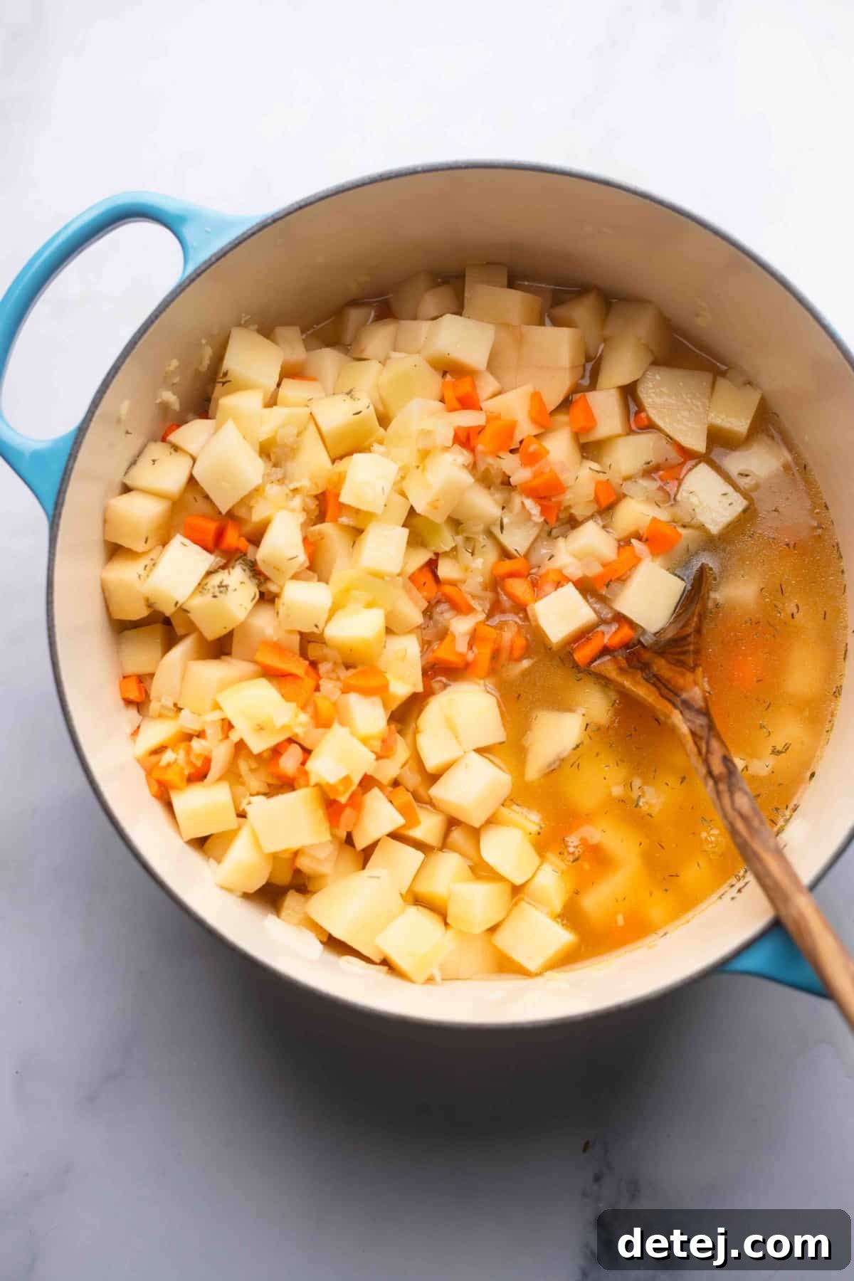 potatoes, carrots and broth in a pot