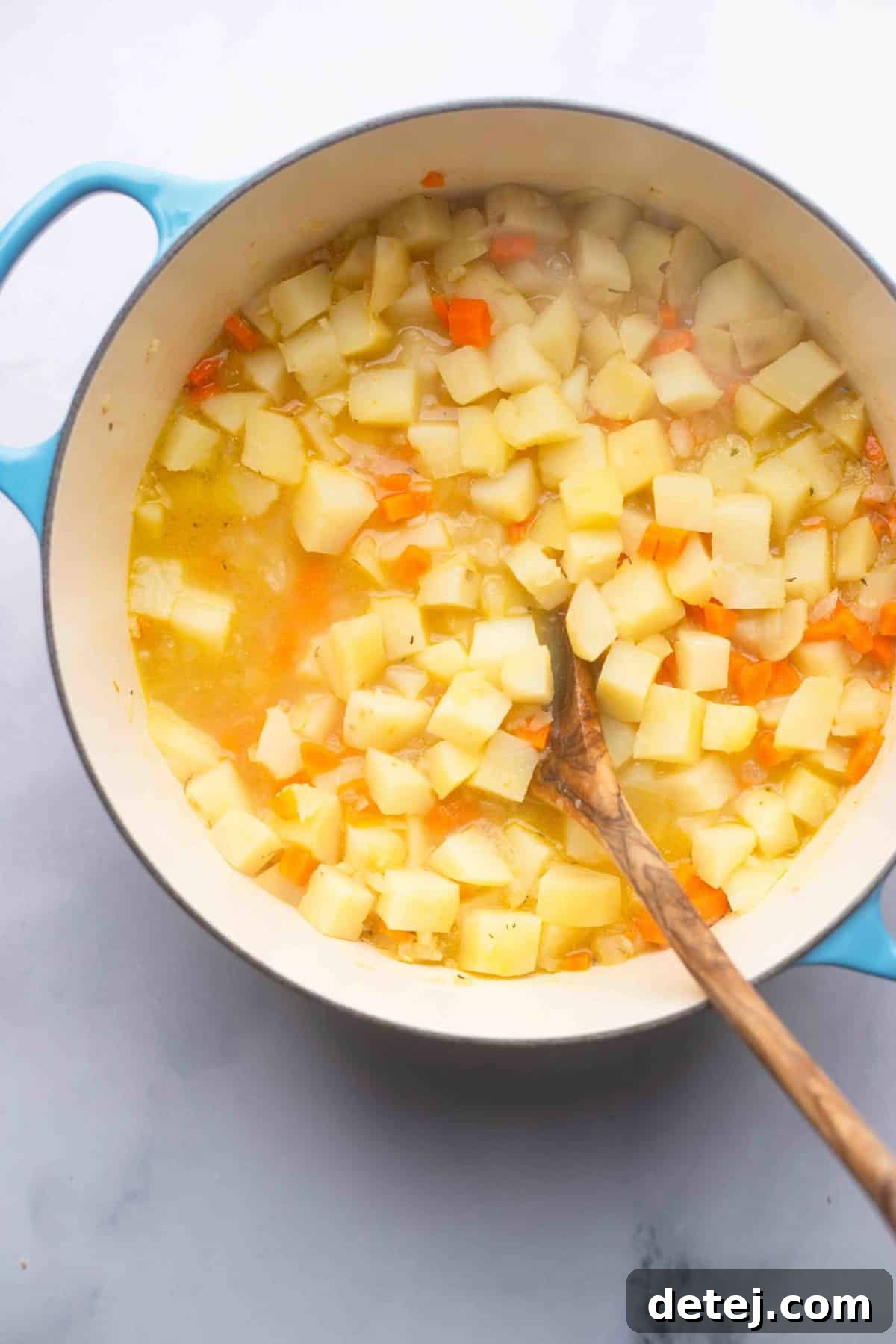 cooked potatoes and carrots in broth