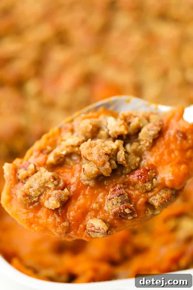 Comforting Vegan Sweet Potato Bake 8 spoon lifting vegan sweet potato casserole