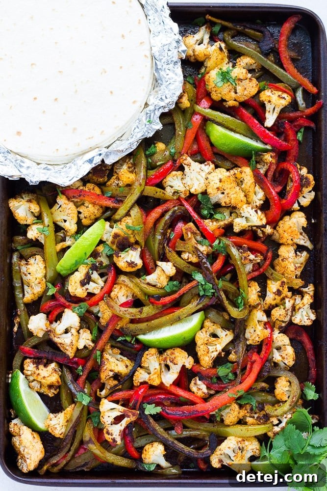 One-Pan Roasted Cauliflower Fajitas 6 A inviting scene of freshly cooked vegetarian cauliflower fajitas served in a pan, accompanied by warm tortillas and vibrant toppings, ready for a delicious meal.