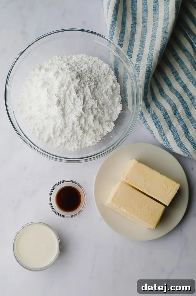Dreamy Vegan Buttercream 3 Key ingredients for vegan buttercream frosting, including softened vegan butter, powdered sugar, non-dairy milk, and vanilla extract, arranged on a white marble backdrop.