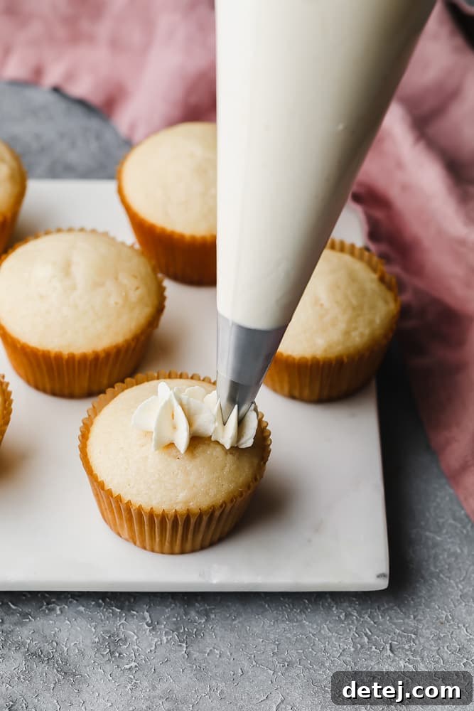 Dreamy Vegan Buttercream 10 A piping bag demonstrating how to create a perfect swirled frosting dollop on a cupcake, starting from the edge and moving inwards and upwards.