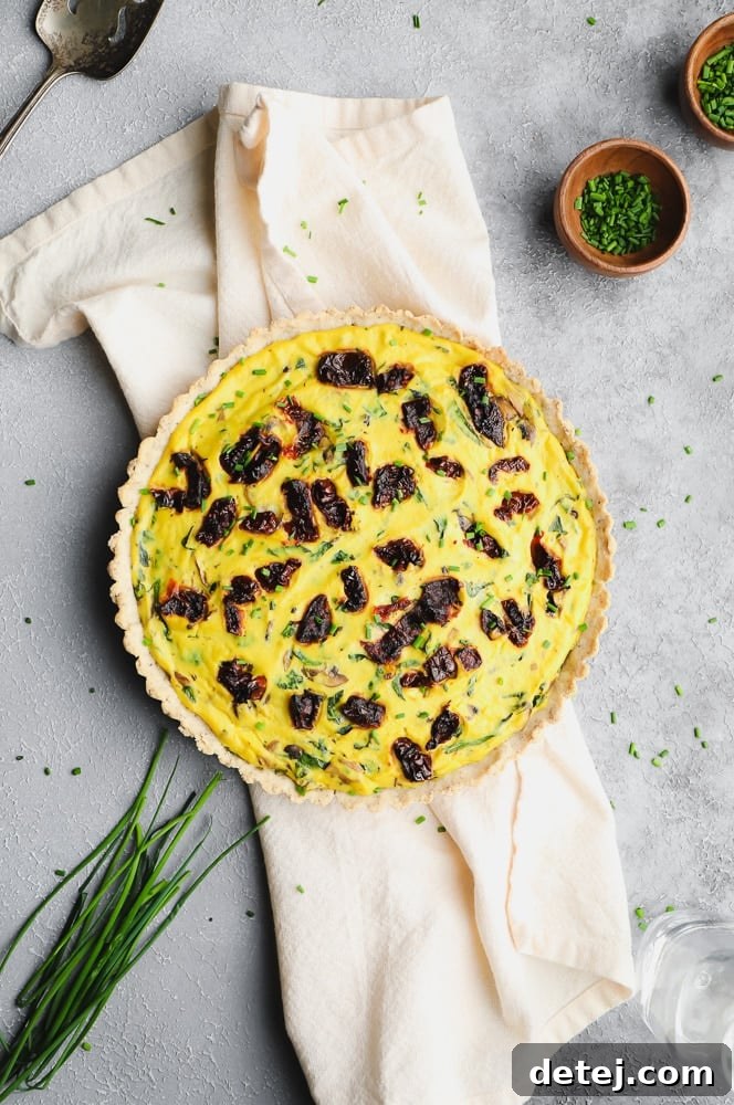 whole uncut quiche with sun dried tomatoes on top
