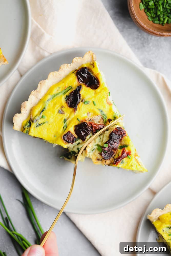 piece of quiche on a plate with a fork taking a bite
