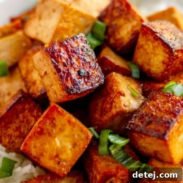 close up on a pile of cooked marinated tofu cubes.