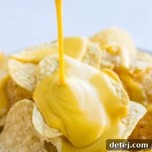 vegan cheese sauce being poured onto chips