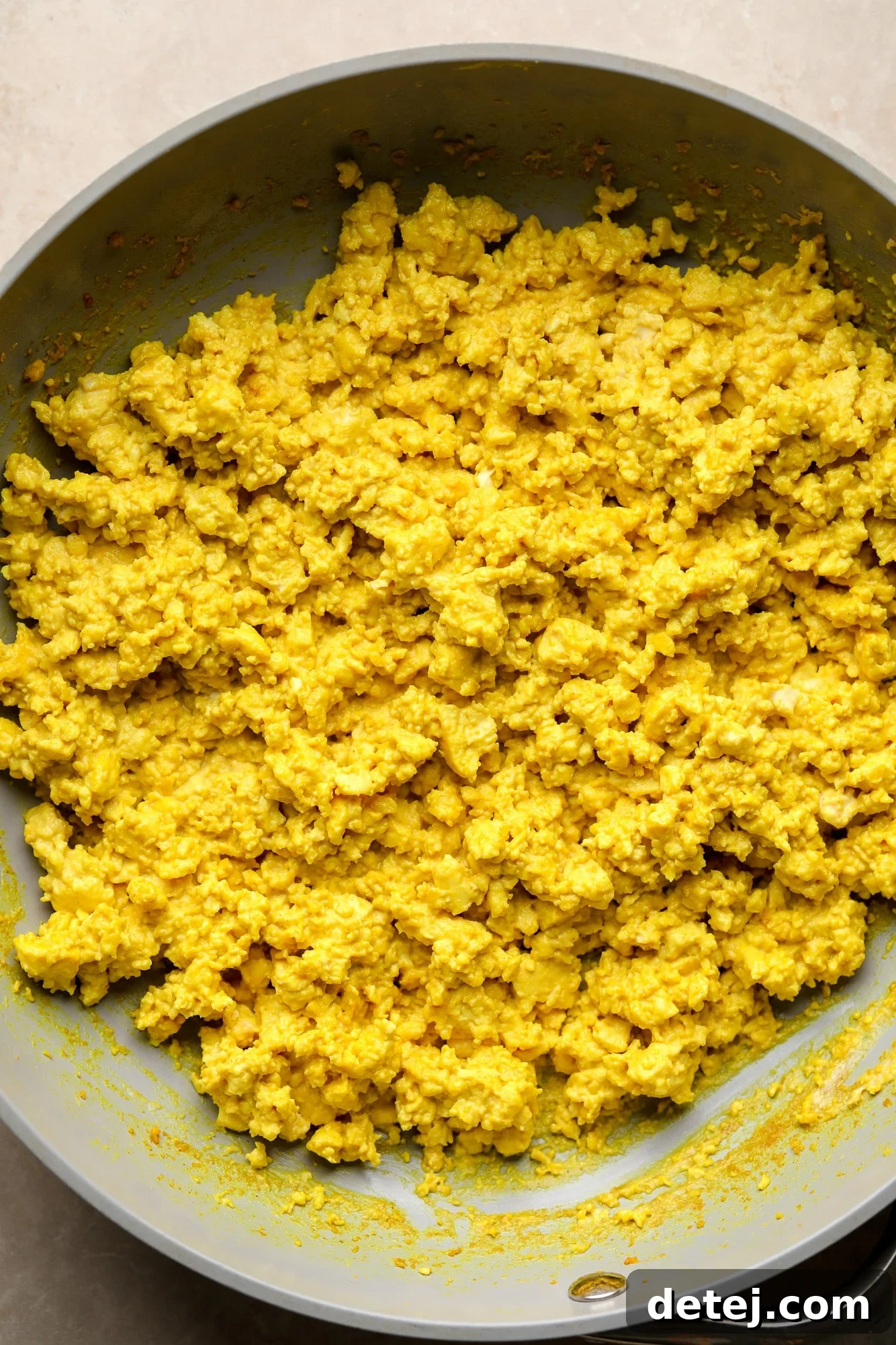 Yellow tofu scramble simmering in a skillet, almost ready to serve.