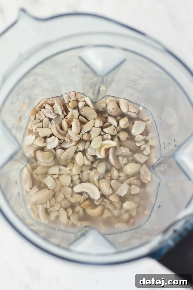 Luscious Vegan Green Goddess Dressing 4 Raw cashews and water in a high-powered blender before blending for creamy vegan dressing.