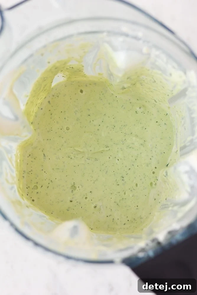 Luscious Vegan Green Goddess Dressing 7 Finished Vegan Green Goddess Dressing swirling beautifully in a high-powered blender, vibrant and smooth.