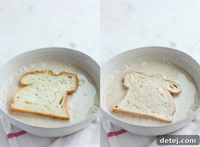 A thick slice of bread soaking deeply in the rich, creamy batter for vegan French toast, absorbing all the delicious flavors.