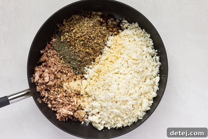 Ingredients for the vegan 'meat' mixture simmering in a pan, showcasing the rich colors and textures.