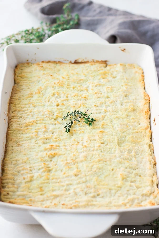 A beautifully cooked vegan shepherd's pie in a casserole dish, prior to being cut and served.