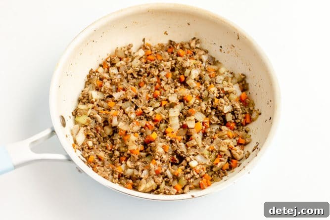white pan full of mushrooms and veggies