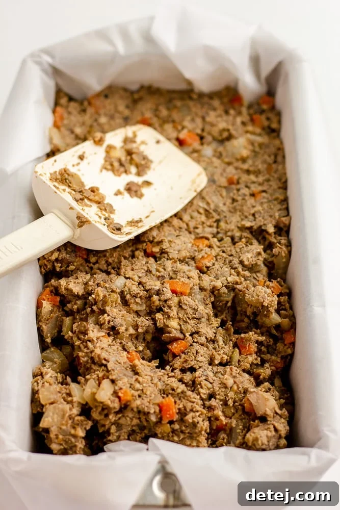 loaf pan lined with parchment and putting in loaf ingredients